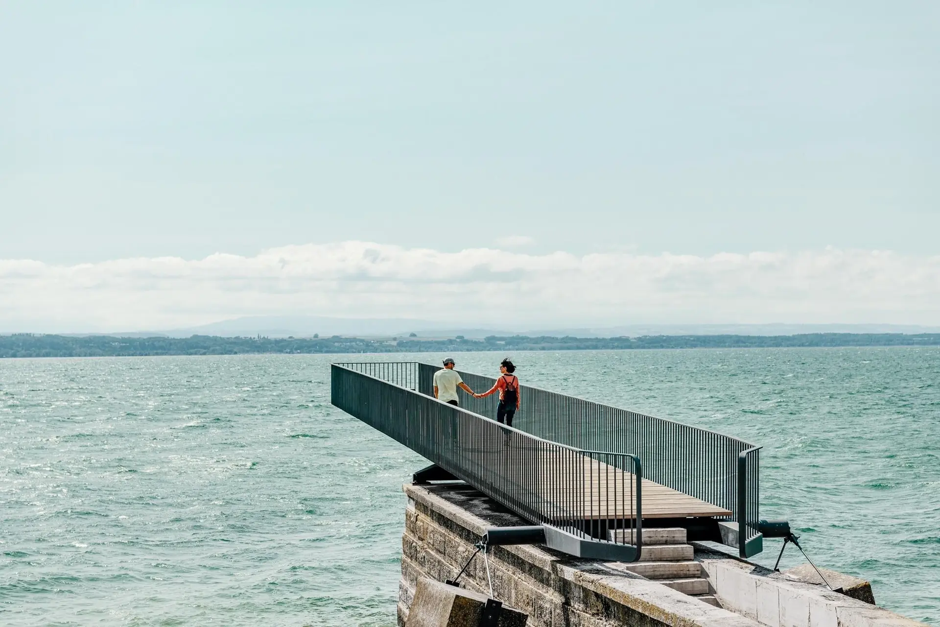 Promeneurs sur un ponton au bord du lac de Neuchâtel